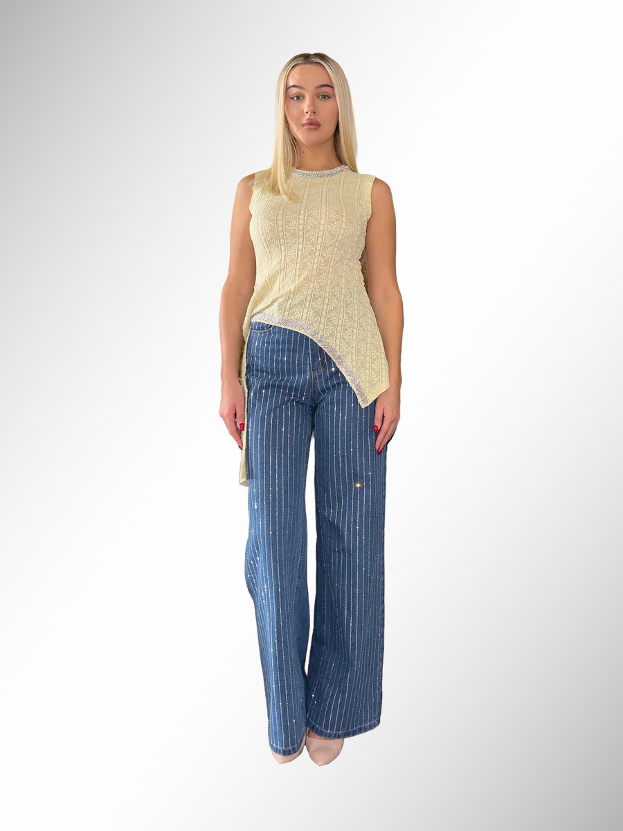 טופ אסימטרי בצבע שמנת עם עיטורי תחרה ומכנסי ג'ינס רחבים עם פסים מנצנצים, אופנת נשים, גיליס